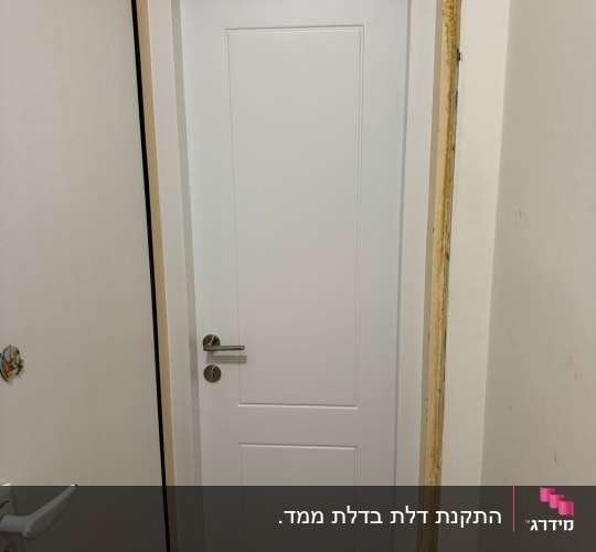 דלת לבנה מותקנת במסגרת חדשה